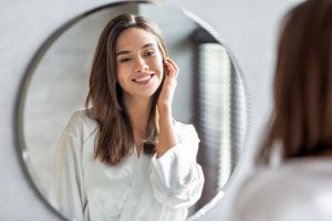 Młoda kobieta przegląda się w lustrze w łazience