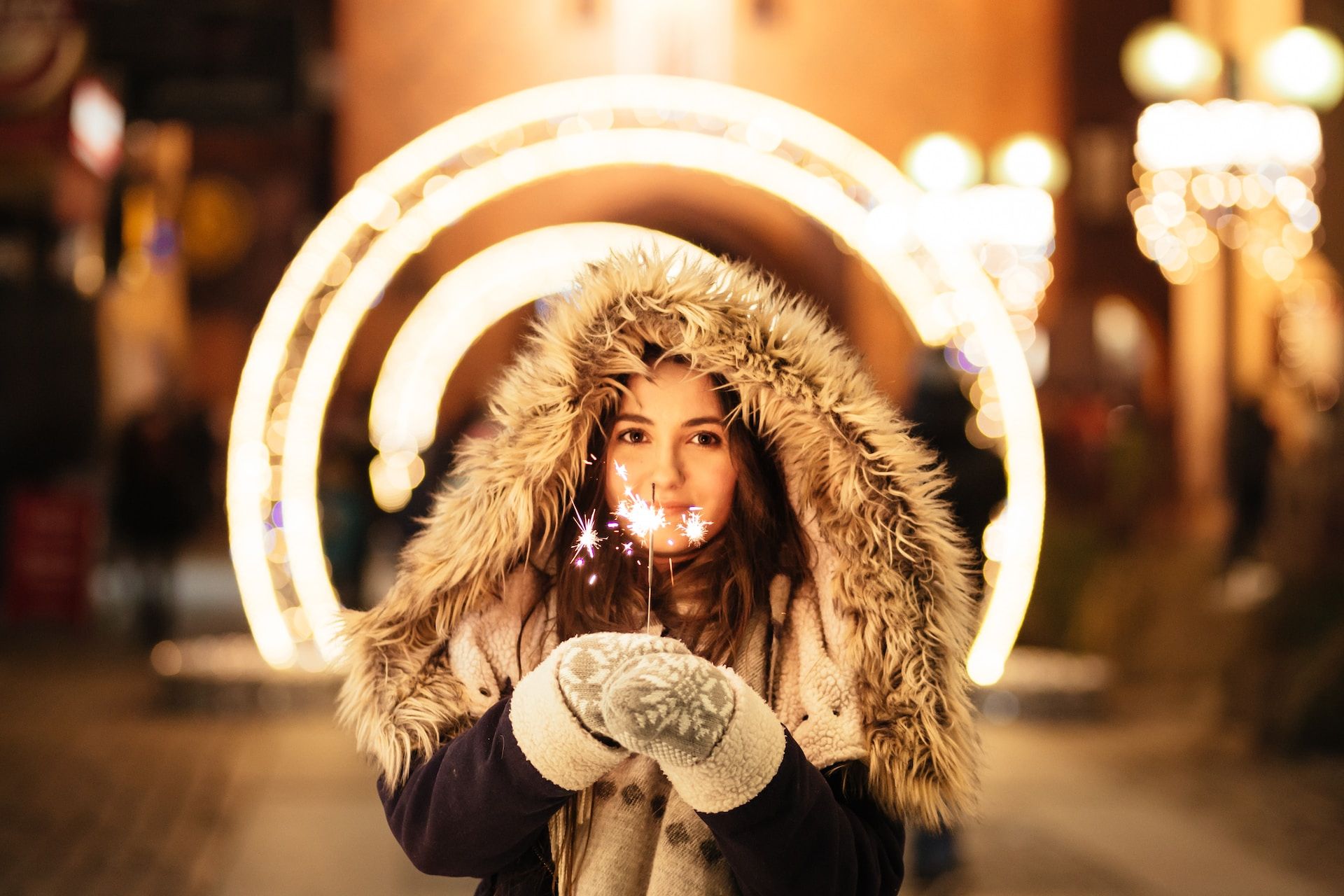 Młoda dziewczyna z zimnymi ogniami witająca nowy rok