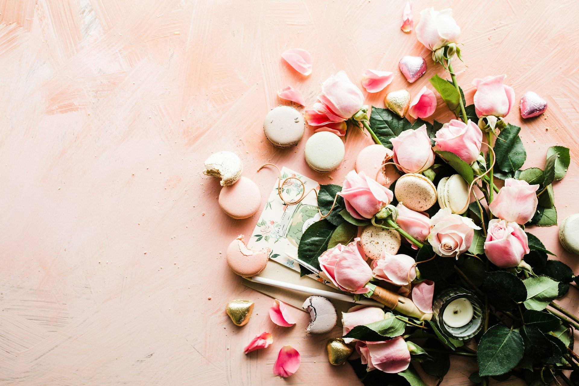 Róże, makaroniki i świece na różowym tle