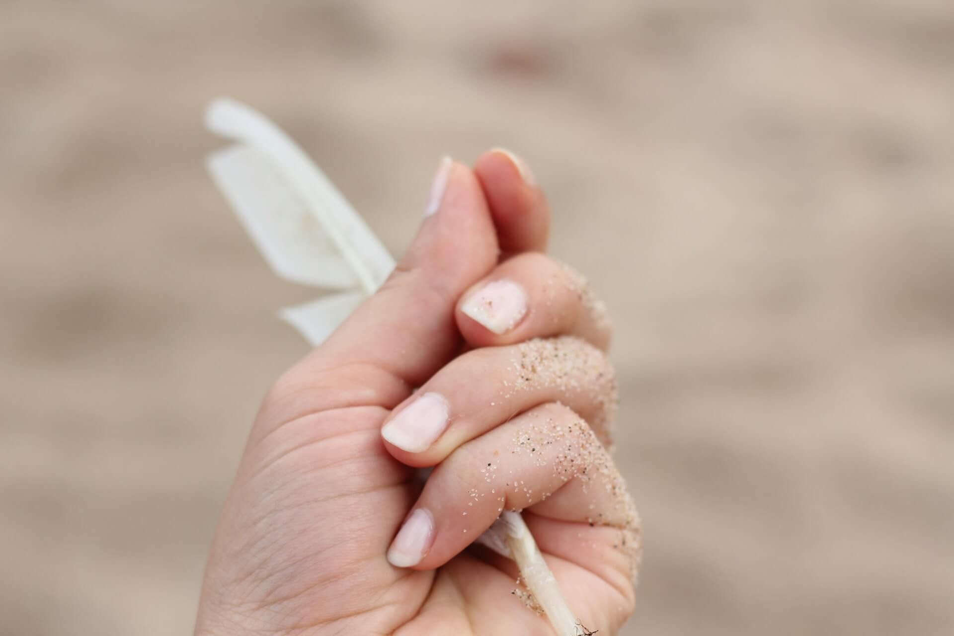 Panzokcie dłoni w piasku na plaży