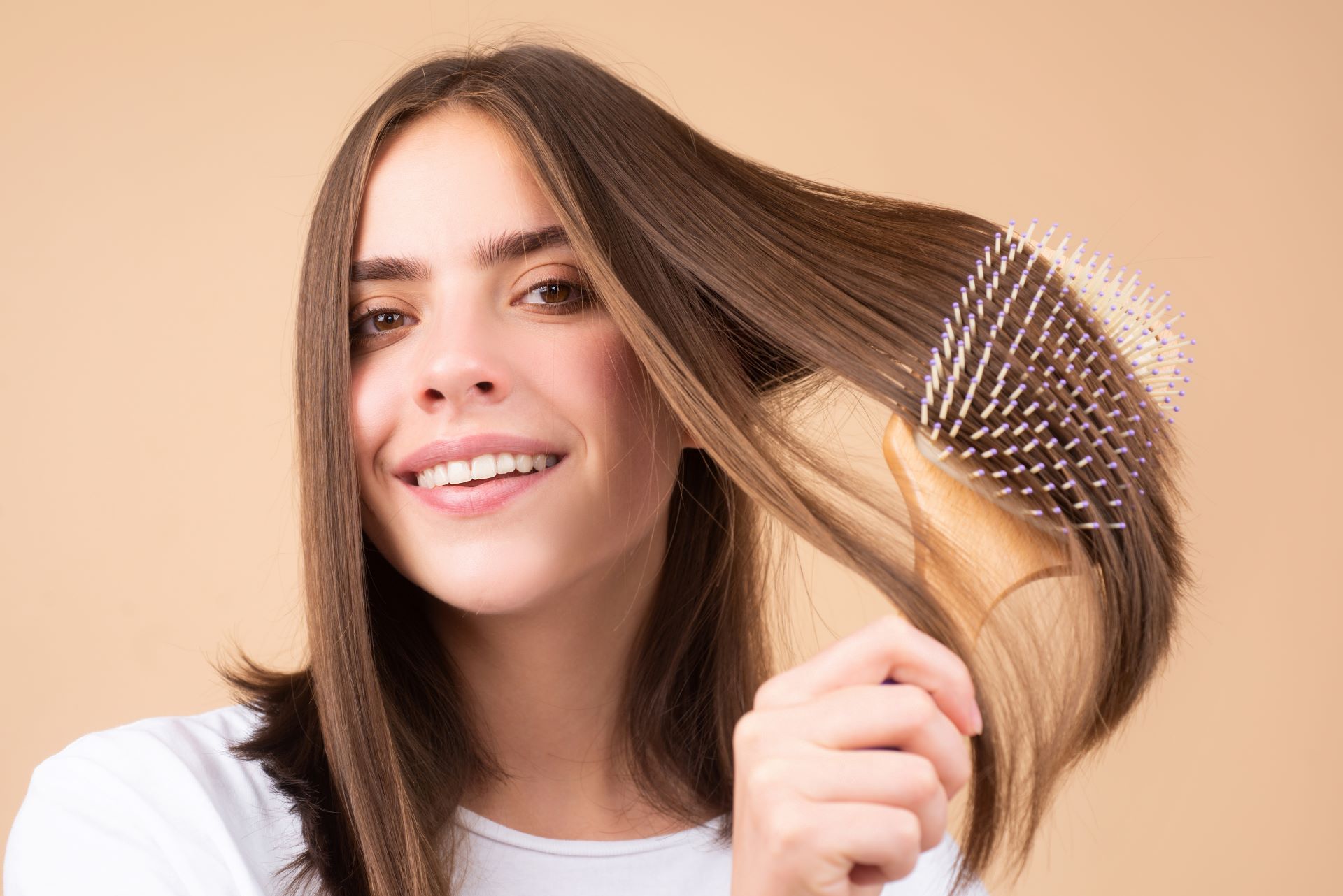Dziewczyna rozczesuje włosy szczotką do włosów